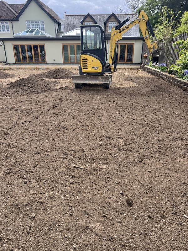 Yellow Yanmar mini digger on a freshly levelled garden in front of a house in Essex